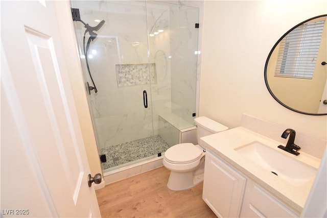 bathroom with vanity, toilet, an enclosed shower, and hardwood / wood-style floors