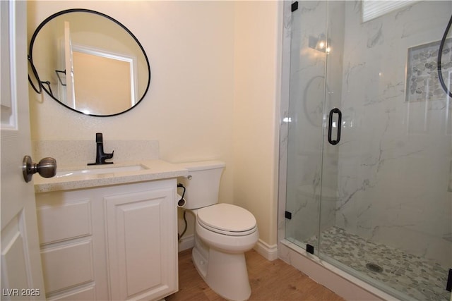 bathroom with a shower with door, vanity, hardwood / wood-style flooring, and toilet