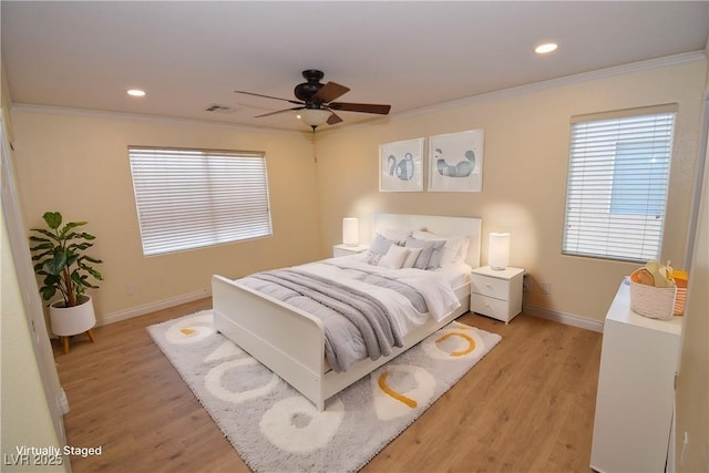 bedroom with crown molding, light hardwood / wood-style flooring, and ceiling fan