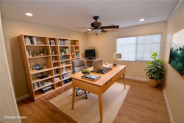 home office with crown molding, ceiling fan, and light wood-type flooring