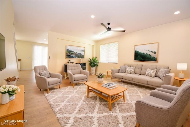 living room featuring wood-type flooring, ceiling fan, and plenty of natural light