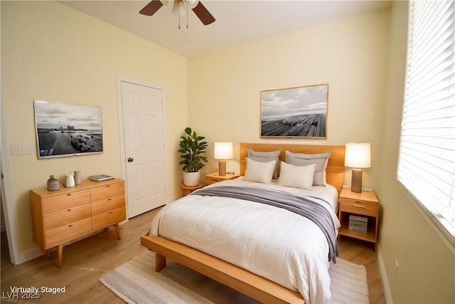 bedroom with ceiling fan, multiple windows, and light wood-type flooring