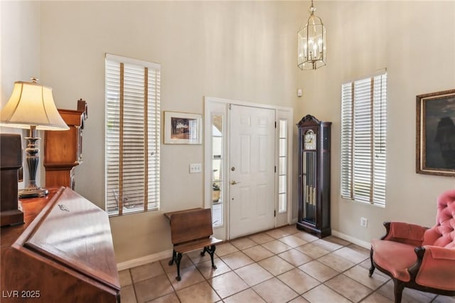 tiled foyer entrance featuring a towering ceiling and a notable chandelier