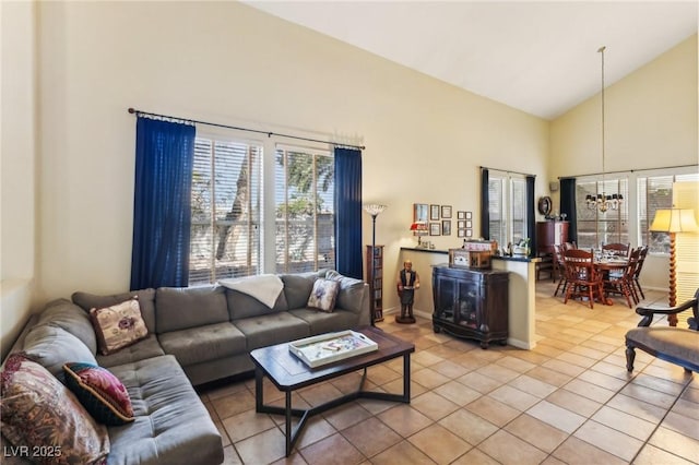 living room featuring light tile patterned flooring, high vaulted ceiling, and a notable chandelier