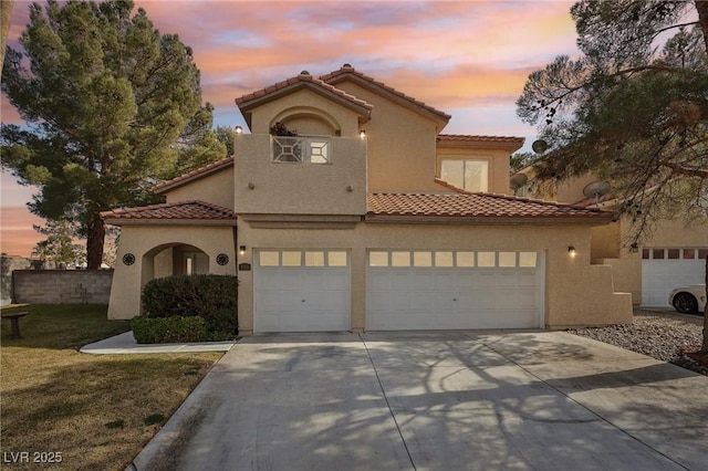 mediterranean / spanish-style home featuring a garage and a lawn