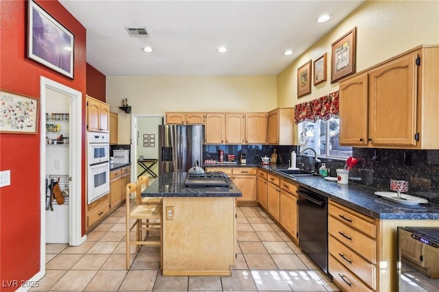 kitchen with a kitchen island, appliances with stainless steel finishes, sink, a breakfast bar area, and backsplash