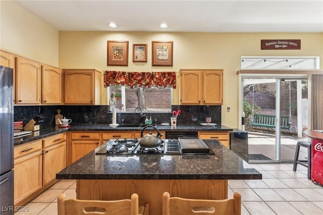 kitchen with light tile patterned floors, sink, and a kitchen island