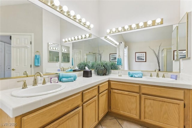 bathroom with tile patterned flooring, vanity, and a shower with door