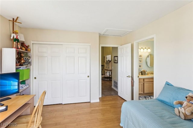 bedroom featuring connected bathroom, light hardwood / wood-style floors, and a closet