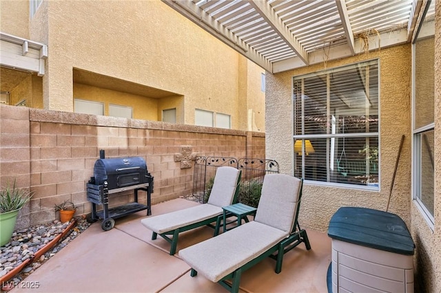 view of patio with area for grilling and a pergola