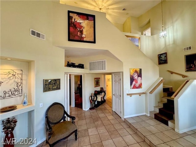 stairs featuring tile patterned floors, a chandelier, and a high ceiling