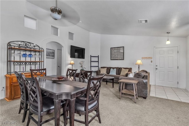 carpeted dining room featuring vaulted ceiling