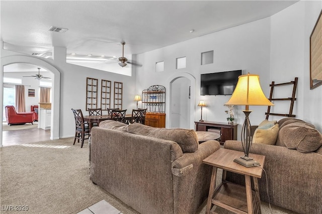 carpeted living room featuring ceiling fan