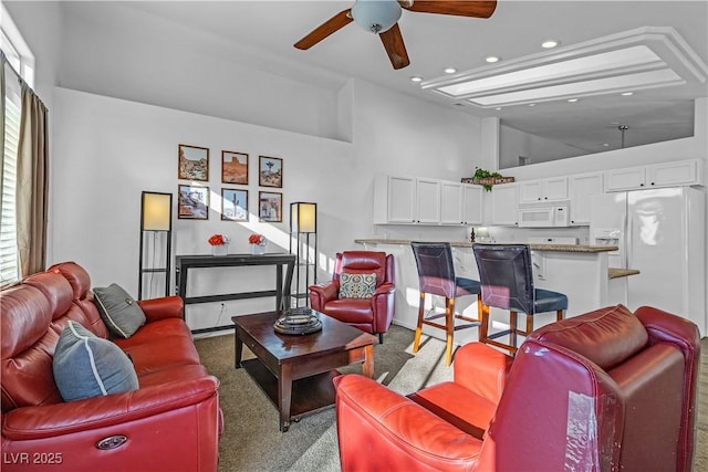 living room featuring ceiling fan, carpet flooring, and high vaulted ceiling