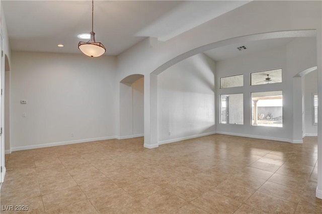 tiled empty room featuring ceiling fan