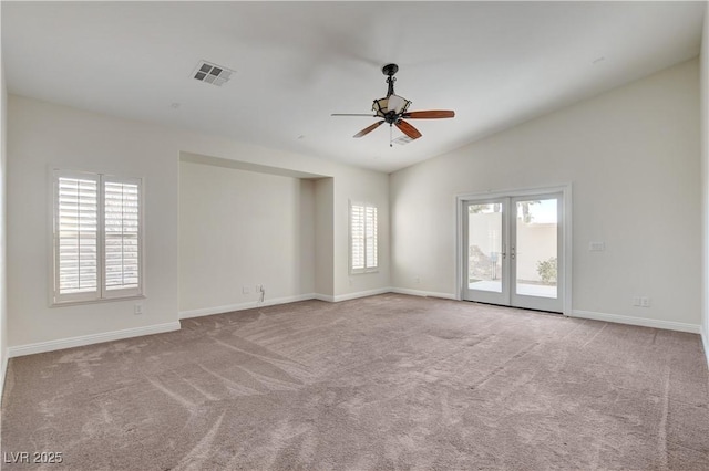 carpeted empty room with vaulted ceiling, french doors, and ceiling fan