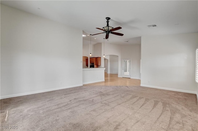 unfurnished living room featuring high vaulted ceiling, light colored carpet, and ceiling fan