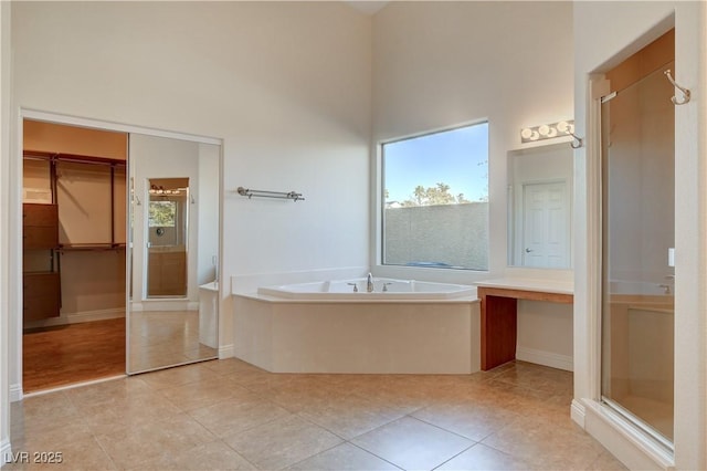 bathroom with a towering ceiling, tile patterned floors, plus walk in shower, and vanity