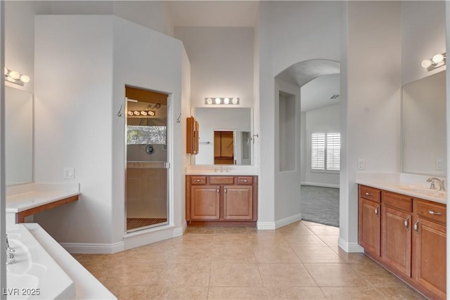 bathroom with a shower with door, vanity, and tile patterned floors