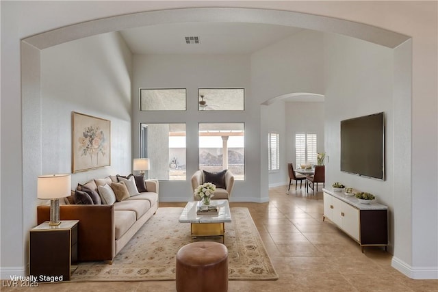 living room featuring light tile patterned floors and a high ceiling