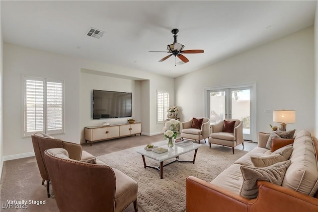 living room featuring vaulted ceiling, a wealth of natural light, and light colored carpet