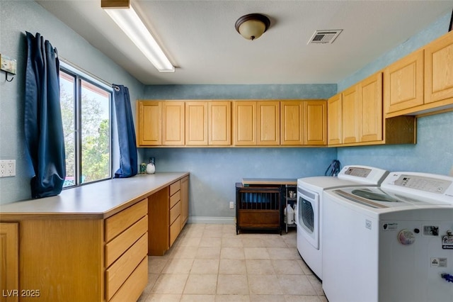 clothes washing area with cabinets, independent washer and dryer, and light tile patterned floors