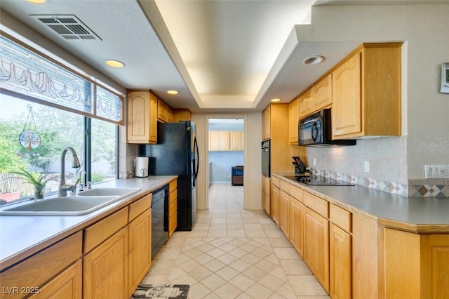 kitchen with tasteful backsplash, light tile patterned flooring, sink, and black appliances