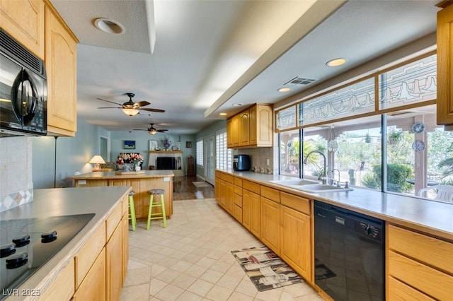 kitchen with tasteful backsplash, ceiling fan, sink, and black appliances