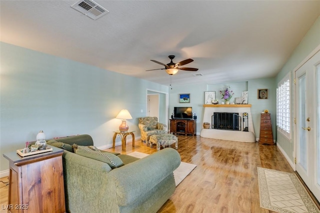 living room with light hardwood / wood-style flooring and ceiling fan