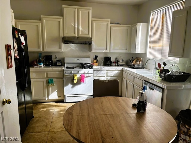 kitchen featuring sink, tile countertops, gas range gas stove, and dishwasher