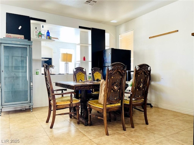 dining area featuring light tile patterned floors, baseboards, and visible vents