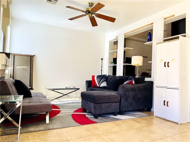 living room with a ceiling fan, visible vents, and light tile patterned floors