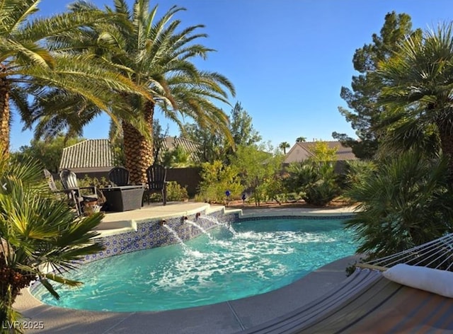 outdoor pool featuring fence and a patio