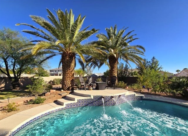 view of pool featuring a patio area, fence, and a fire pit