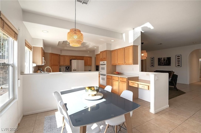 dining space featuring arched walkways, visible vents, recessed lighting, and light tile patterned floors