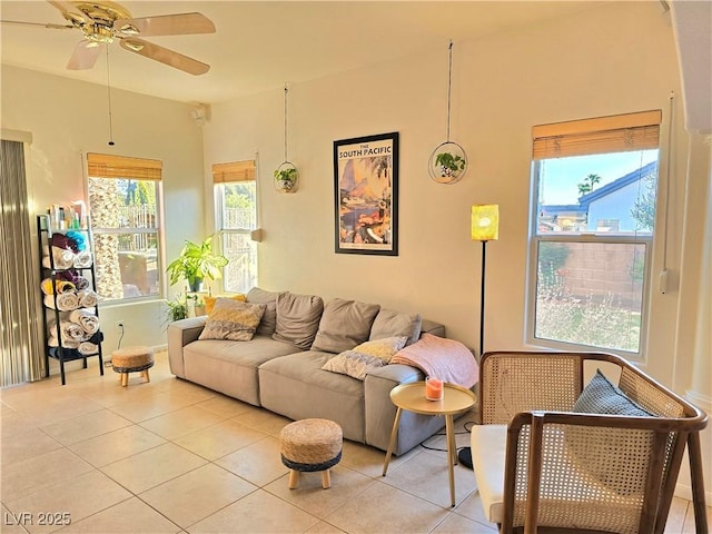 living room with a wealth of natural light, light tile patterned flooring, and ceiling fan