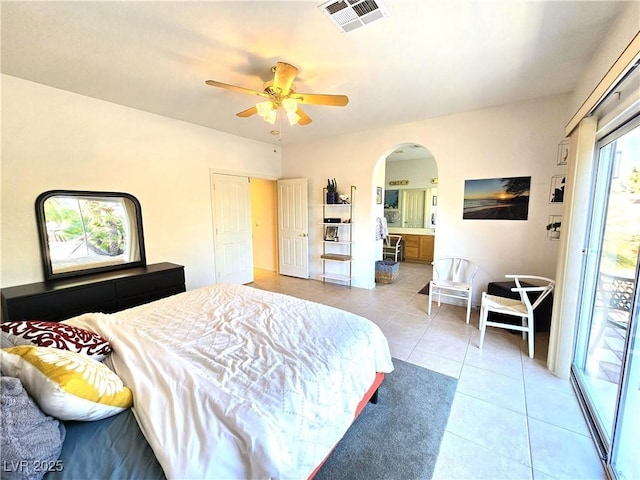 bedroom with visible vents, arched walkways, ensuite bathroom, access to exterior, and light tile patterned flooring