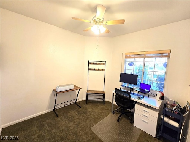 office area with a ceiling fan, dark carpet, and baseboards