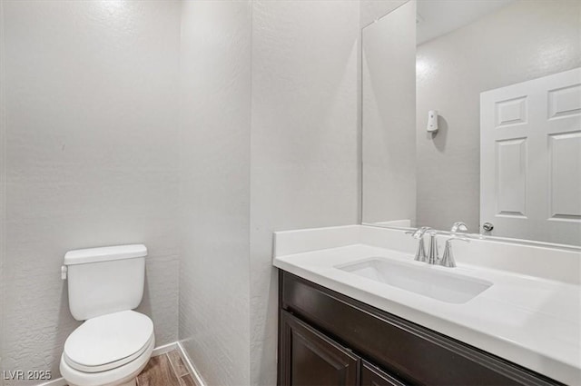 bathroom featuring hardwood / wood-style flooring, vanity, and toilet