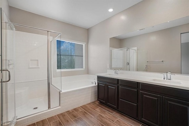 bathroom featuring shower with separate bathtub and vanity