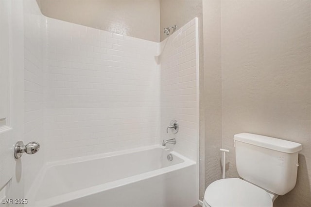 bathroom with tub / shower combination and toilet