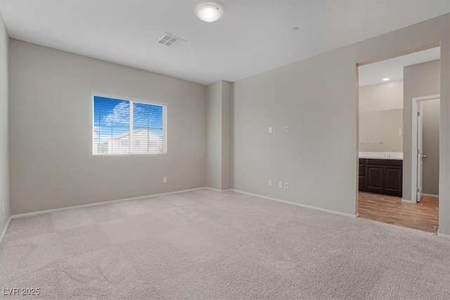 unfurnished room with sink and light carpet