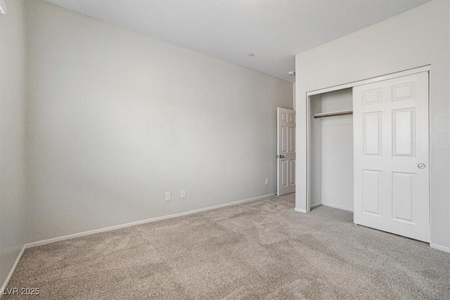 unfurnished bedroom with light colored carpet and a closet