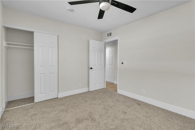 unfurnished bedroom featuring light carpet, ceiling fan, and a closet