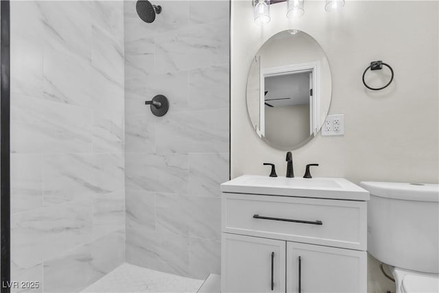 bathroom with vanity, toilet, and a tile shower