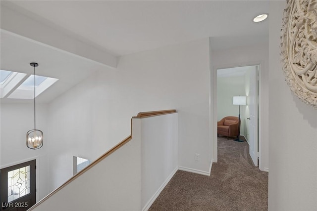 corridor with carpet flooring and lofted ceiling with skylight