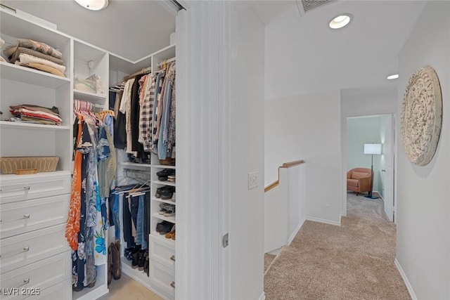 walk in closet featuring light colored carpet