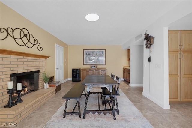 dining space featuring light tile patterned floors and a fireplace