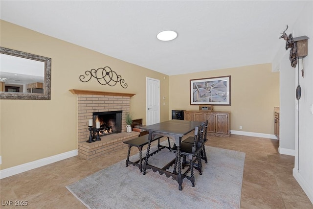 dining area featuring light tile patterned floors and a fireplace