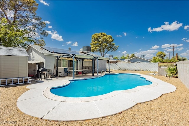 view of swimming pool featuring a patio, central AC unit, and a shed